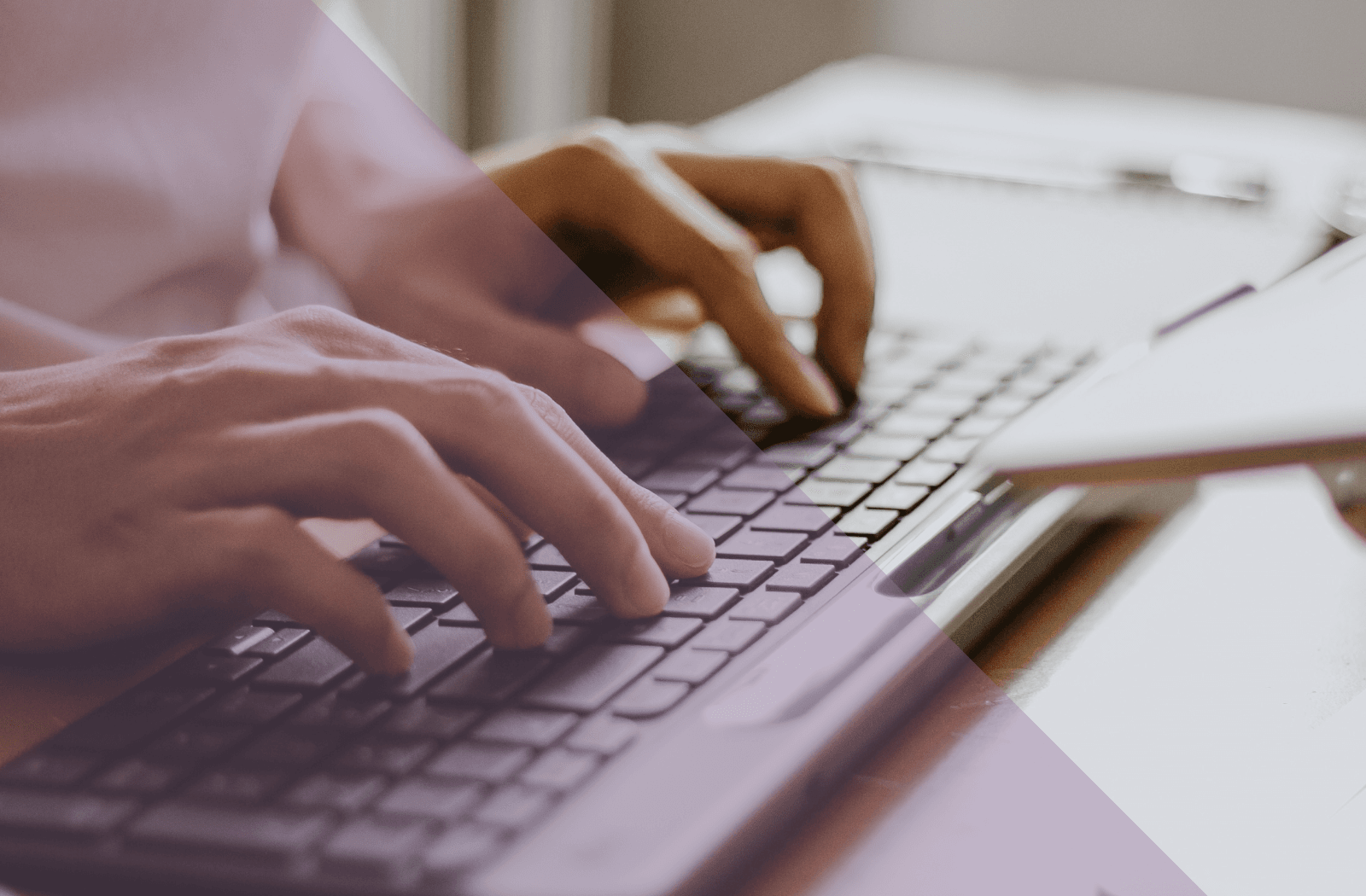 A close up view of hands typing on a keyboard